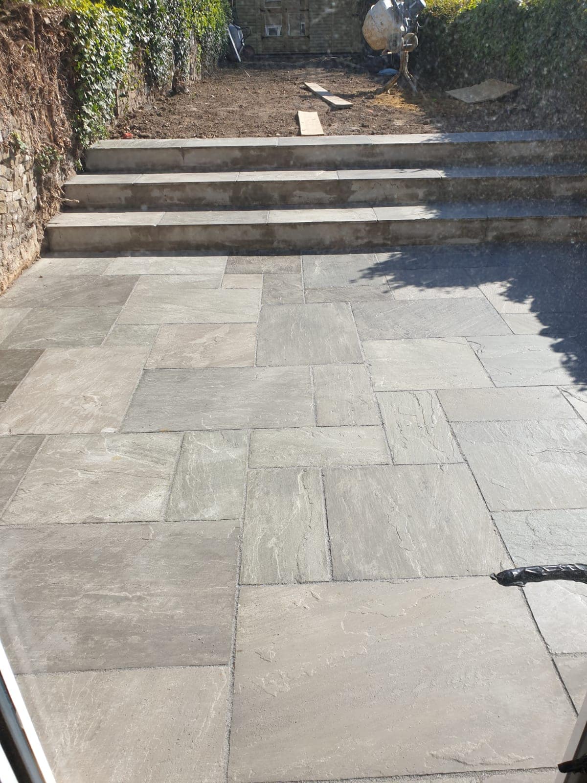 Stone patio with three stone steps - Jackson Landscaping