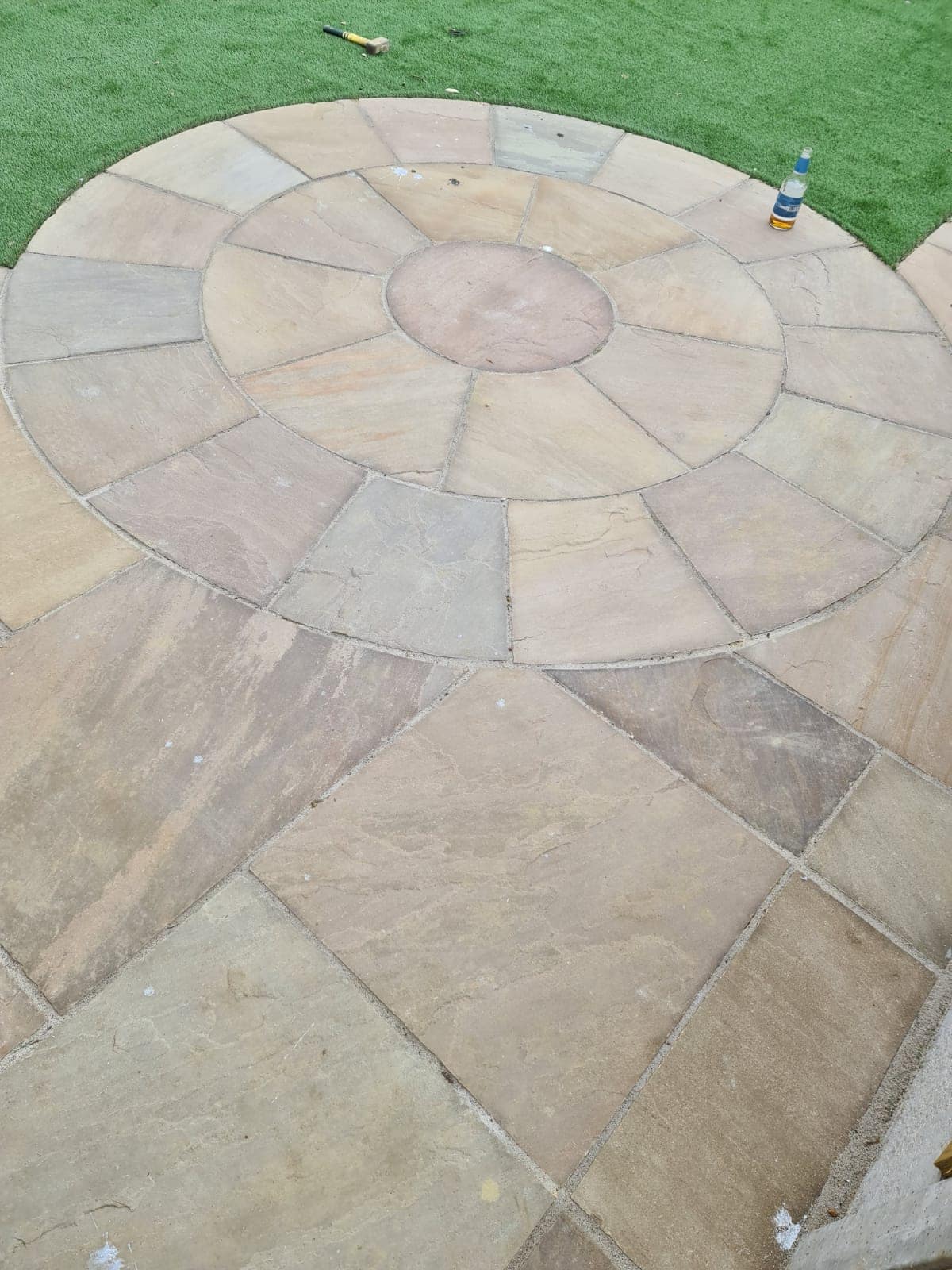Circular sandstone paving with artificial lawn - Jackson Landscaping